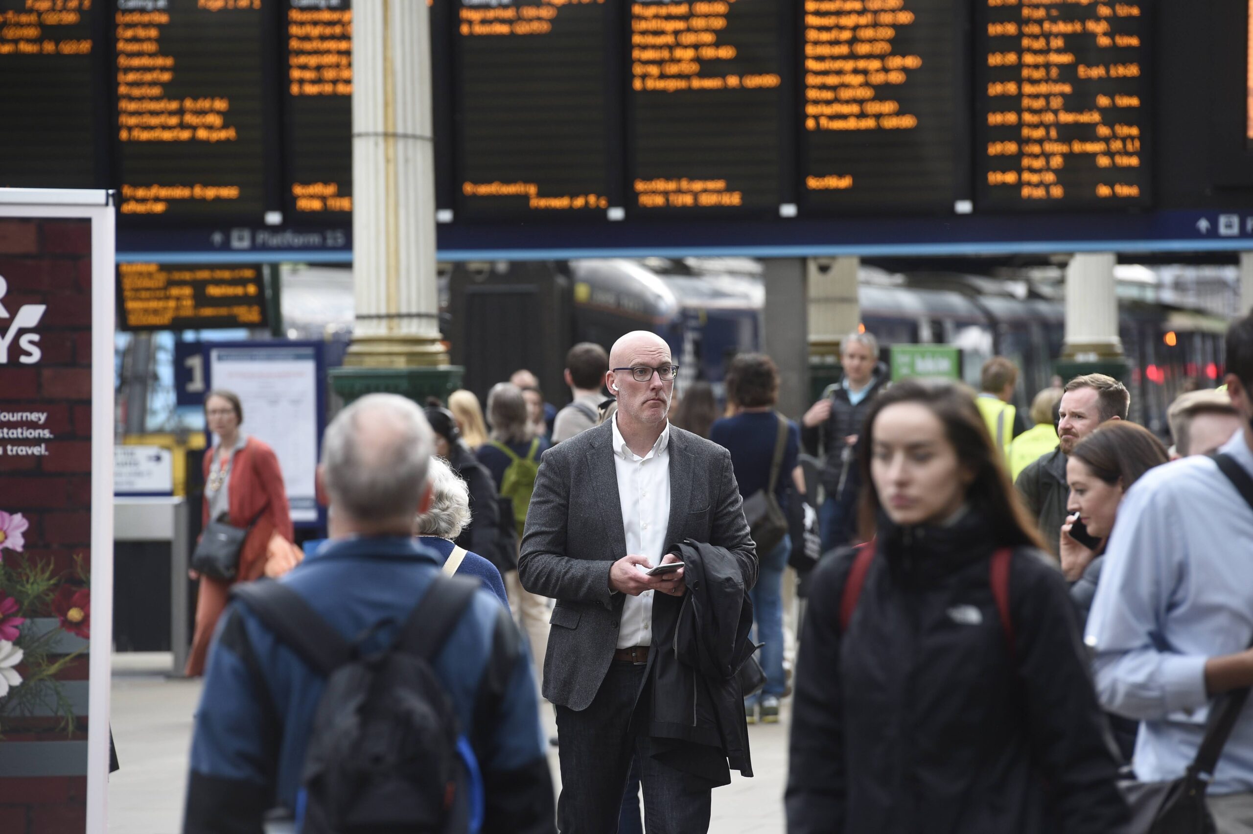 Passengers walking through a train station.