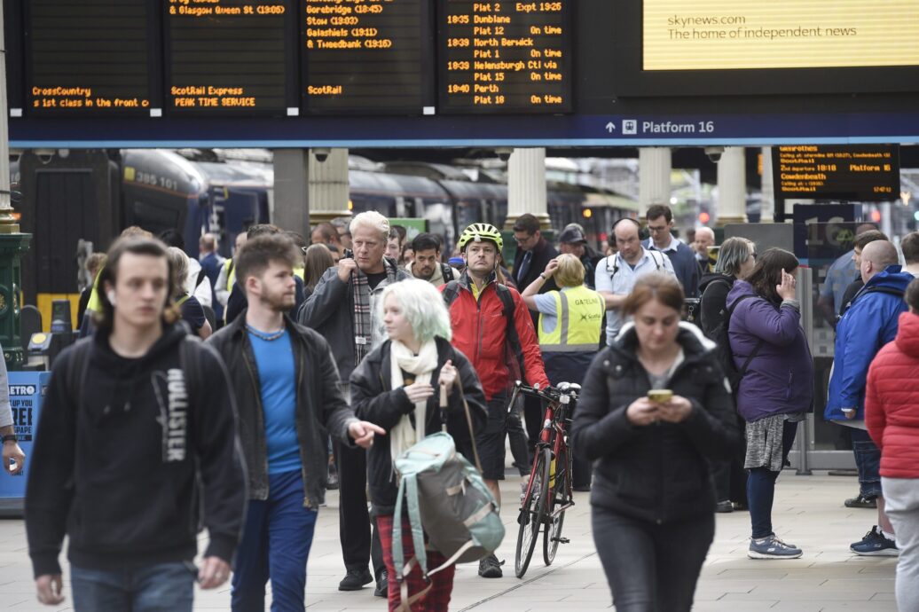 Passengers walking through a train station.