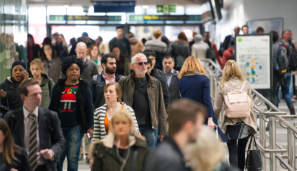 Passengers walking through a train station.